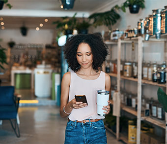 Chica con un smartphone en la mano dentro de una habitación muy ‘green’ (verde)