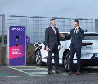 Two businessmen with an electric car at a Juice2Grid charging station