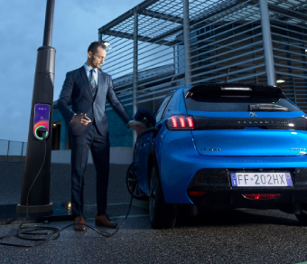 Man charging his electric car at an Enel X JuiceLamp charging station