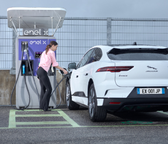 Woman charging her car at an Enel X JuicePump charging station