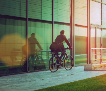 Uomo in bicicletta costeggia un edificio