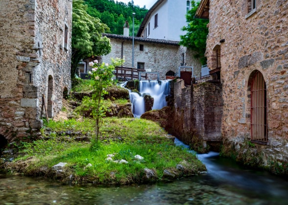 A small waterfall next to some houses in Rasiglia